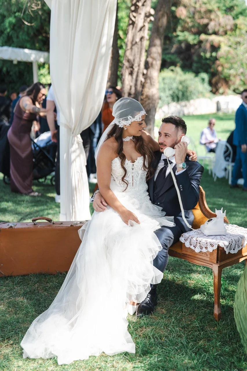 Sposo al telefono vintage mentre la sposa lo guarda sorridendo